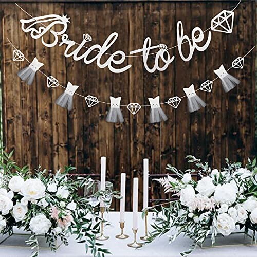 Bride and groom embracing under 'Bride to be' banner in forest setting