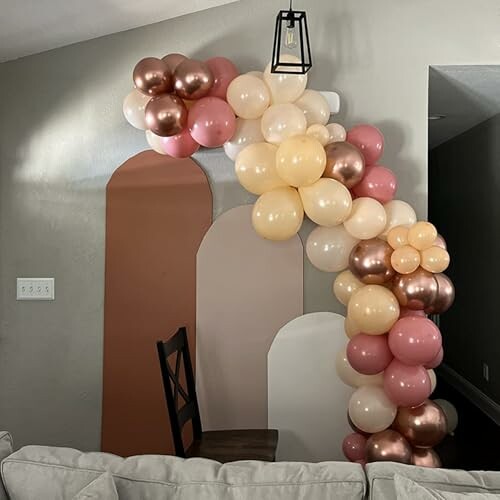 Colorful balloon arch with pink, peach, gold, and cream balloons