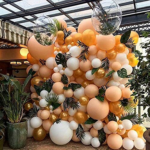 Colorful balloon arrangement with greenery in a decorated space.