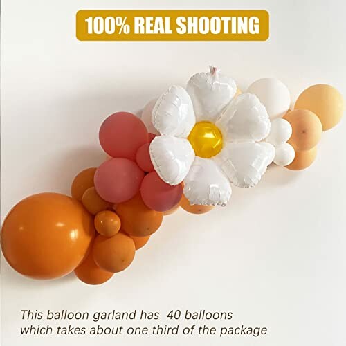 Balloon garland with white flower and orange balloons.