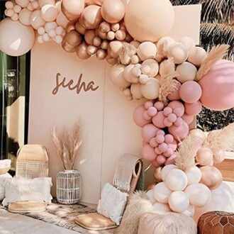 Boho-chic baby shower decor with pastel balloons and pampas grass.