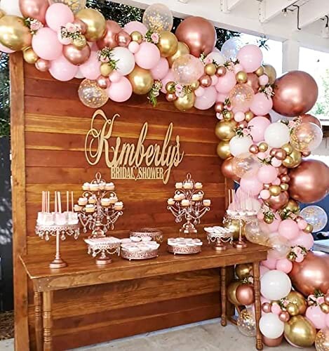 A beautiful bridal shower setup with pink and gold balloons and dessert table, featuring the Beaumode Balloon Garland Arch as the centerpiece.