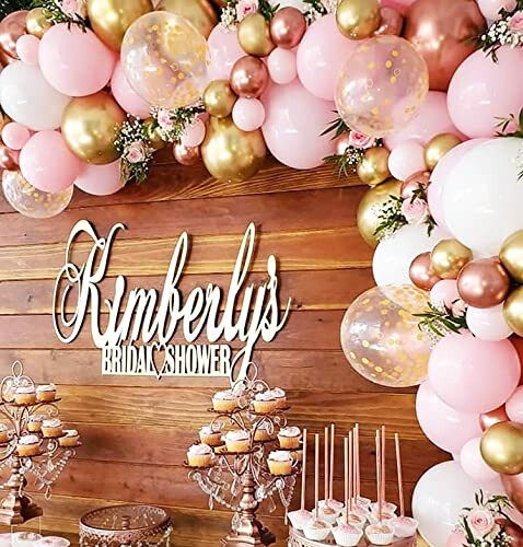 A beautiful bridal shower decor with pink and gold balloons and cupcakes, featuring the Beaumode Balloon Garland Arch as the centerpiece.