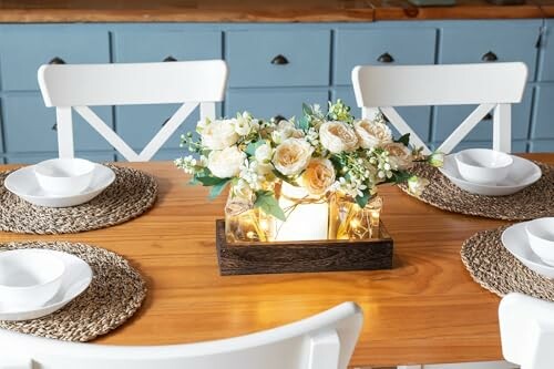 A dining table with a floral centerpiece and four place settings.