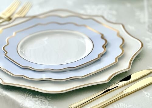 Elegant dinnerware with gold trim on a table.