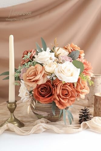 Elegant floral centerpiece with candles and pinecone