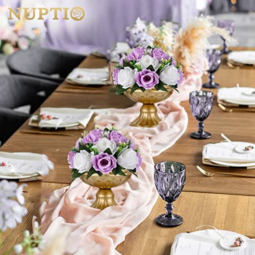 Elegant table setting with floral centerpieces and purple glasses.