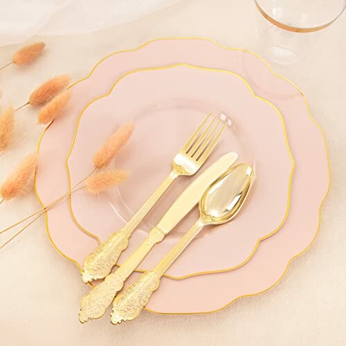 Elegant table setting with pink plates and gold cutlery.