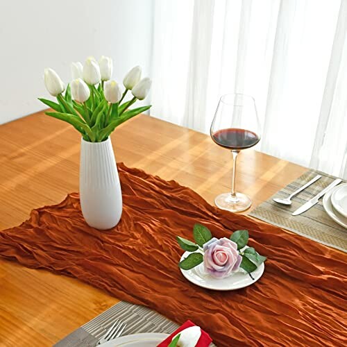 Elegant table setting with white tulips, wine glass, and decorative rose.