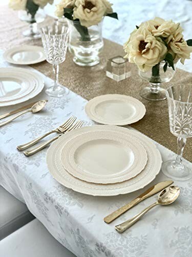 Elegant table setting with white plates, crystal glasses, and cream roses.