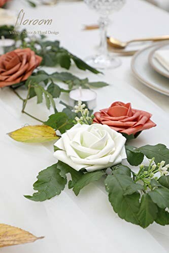 Table centerpiece with white and orange roses and greenery