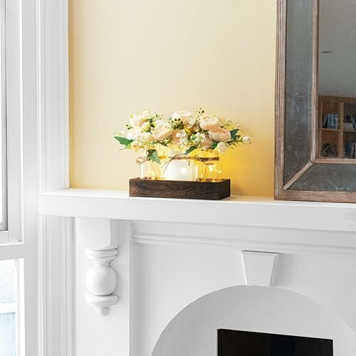 Flower vase with lights on white mantelpiece