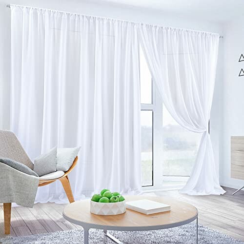 Bright living room with white curtains and minimalist decor.