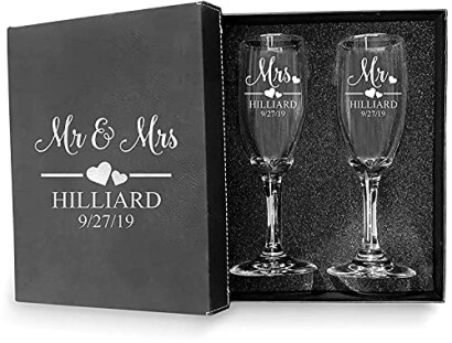 Set of two personalized champagne flutes with 'Mr & Mrs' text and wedding date.