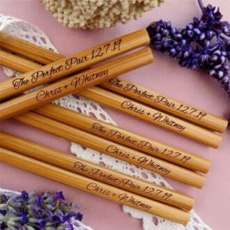 Personalized wooden pencils with 'The Perfect Pair' inscription surrounded by purple flowers.