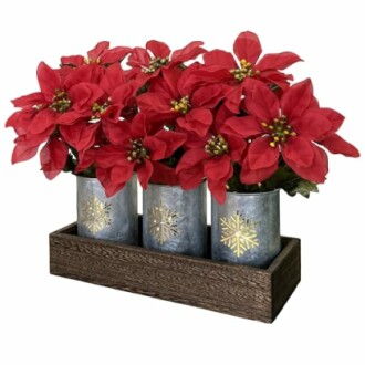 Red poinsettias in decorative metal pots with snowflake designs.