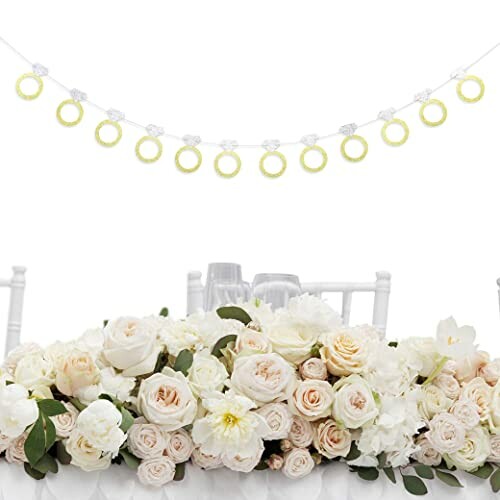 Wedding table with white and pink roses, floral garland, and chair decorations