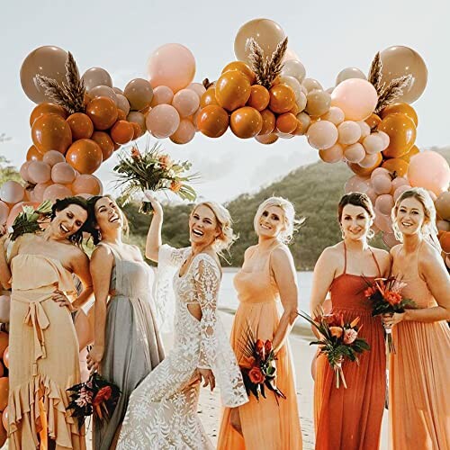 Bride and bridesmaids in colorful dresses with balloon arch.