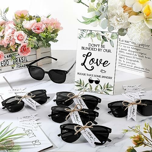 Table with sunglasses and floral decor for wedding gifts.