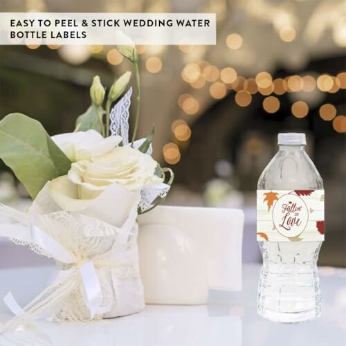 Wedding water bottle with decorative label next to white floral centerpiece.